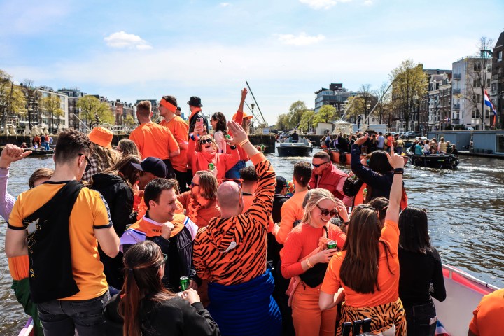 a group of people standing next to a body of water