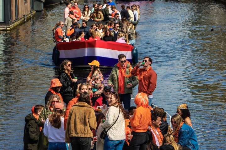 a group of people in a small boat in a large body of water